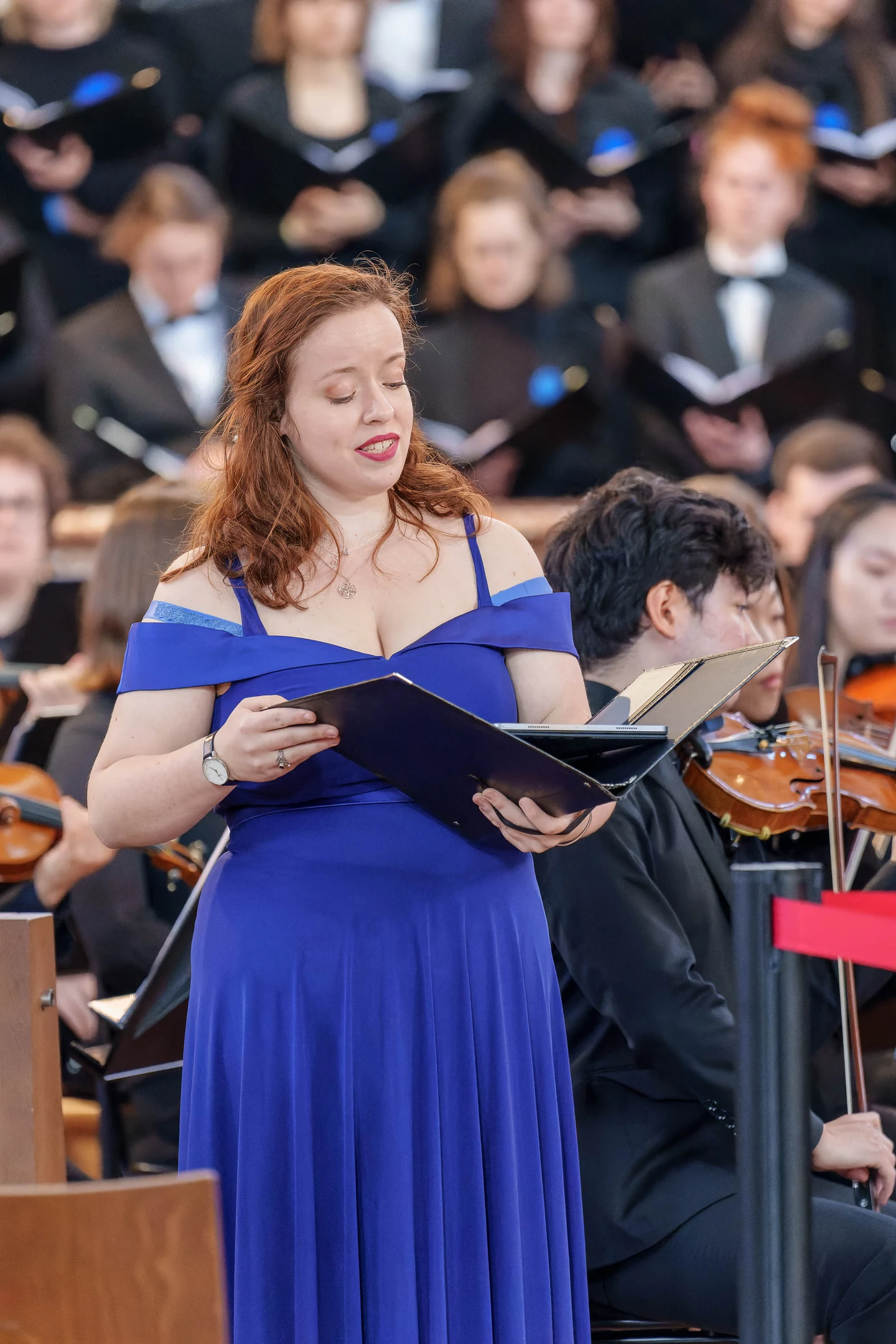 Donata Meyer-Kranixfeld singing in a blue gown with choir and orchestra